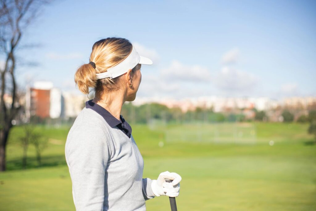 Female golfer with sun visor looking at the golf course in Portugal