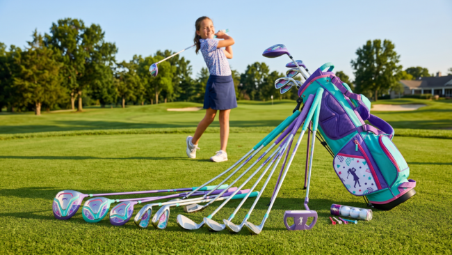 Junior golf club set for girls in purple, pink and teal with lightweight shafts and matching bag on golf course green